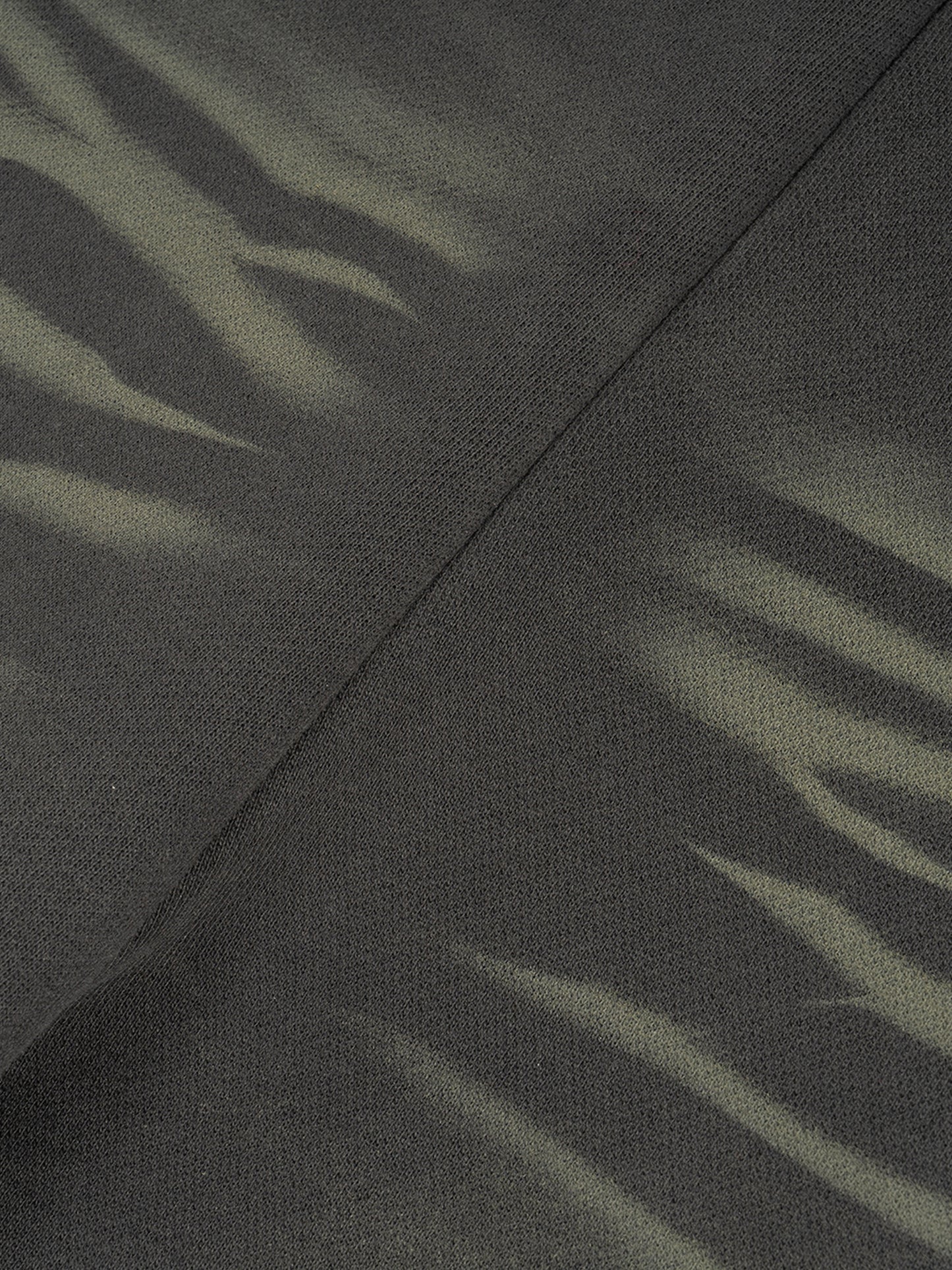 ODMPOD Sunfade Curved Blade fleece sweatpants displayed on a hanger, showcasing their relaxed fit and soft fabric.
