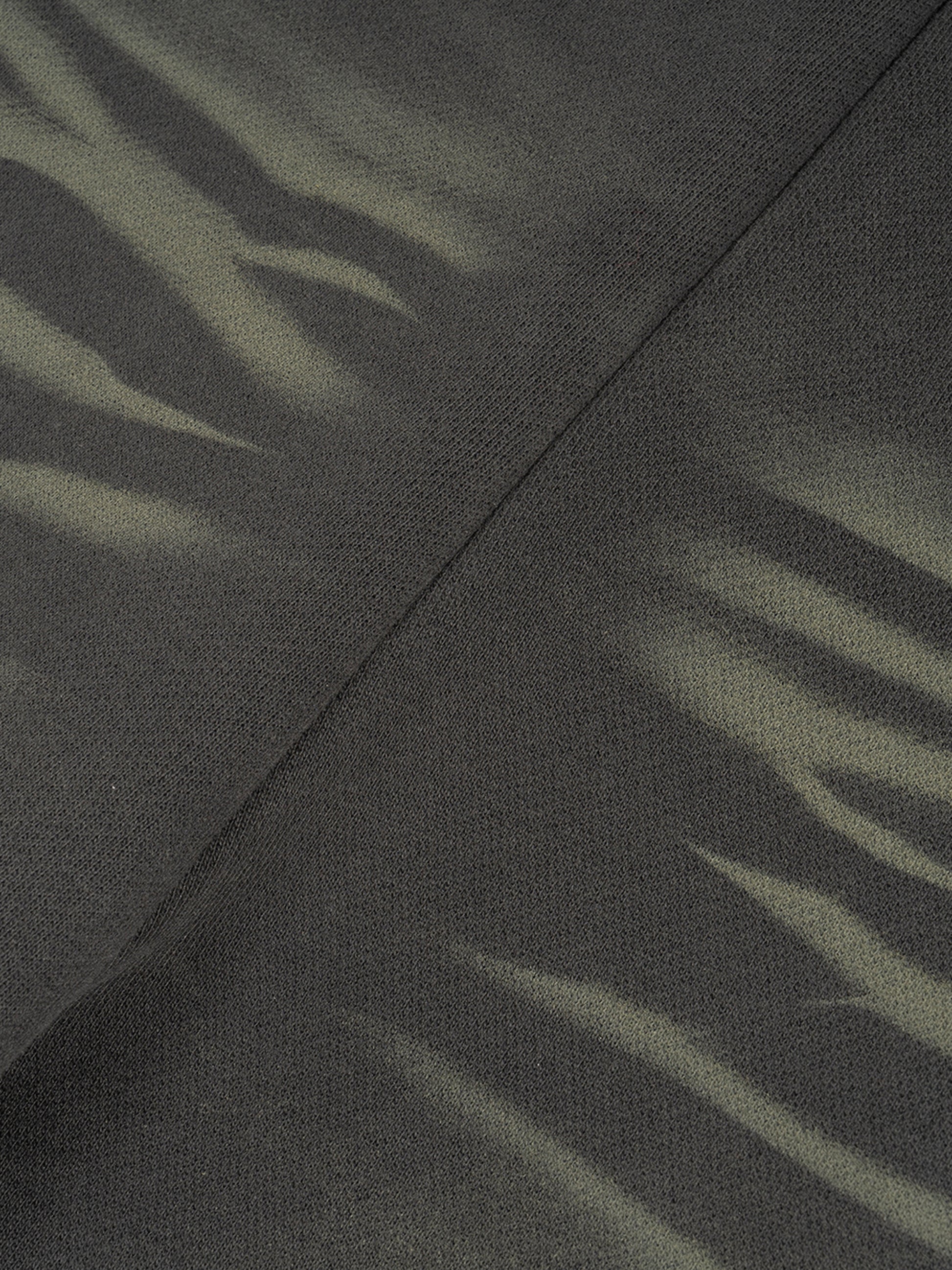 ODMPOD Sunfade Curved Blade fleece sweatpants displayed on a hanger, showcasing their relaxed fit and soft fabric.