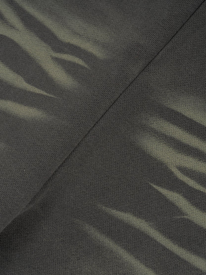 ODMPOD Sunfade Curved Blade fleece sweatpants displayed on a hanger, showcasing their relaxed fit and soft fabric.