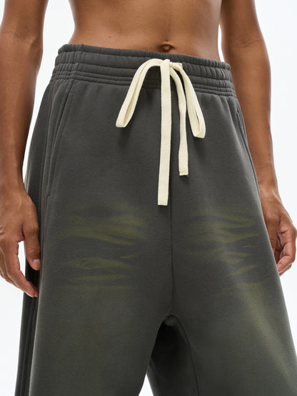ODMPOD Sunfade Curved Blade fleece sweatpants with elastic waistband and curved design, shown in a relaxed fit.
