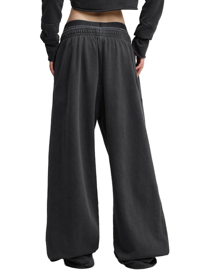 Vintage washed waist pants by ODMPOD, featuring a relaxed fit and distressed denim look, shown on a model.